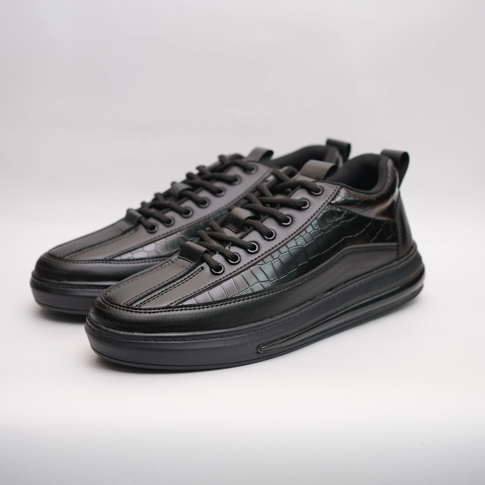 Black leather sneakers on a light gray background