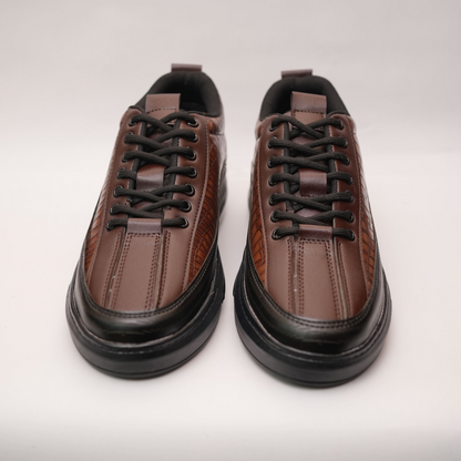 Pair of brown leather sneakers on a light gray background