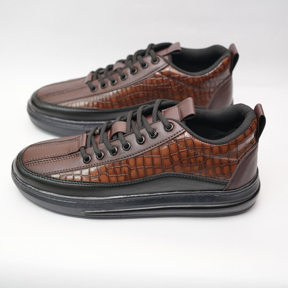 Pair of brown leather shoes with black soles on a light gray background